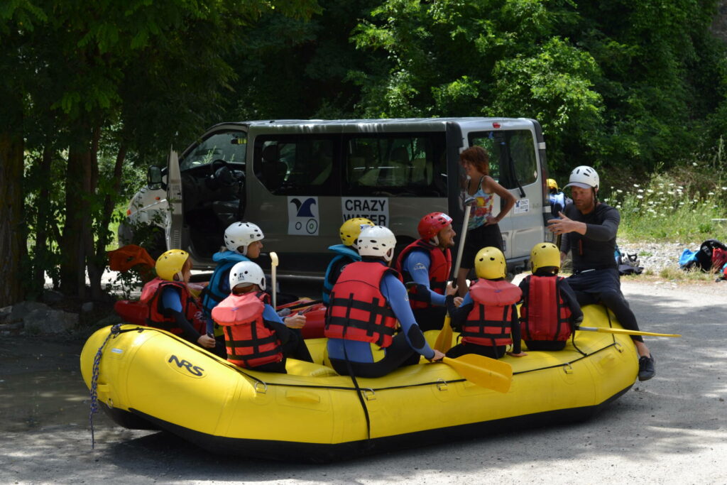 Assis dans le raft, on écoute les explications pour faire une descente dans les Alpes en toute sécurité.