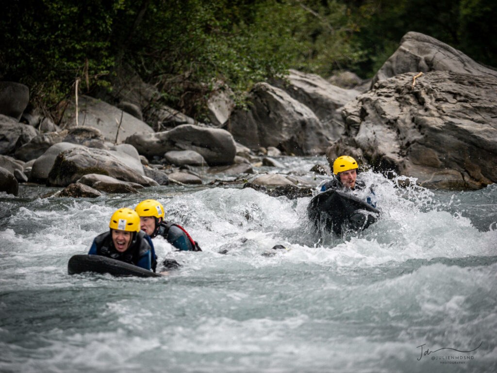 Pratique de l'hydrospeed sur la rivière Ubaye, avec trois sportifs équipés de casques jaunes et de flotteurs