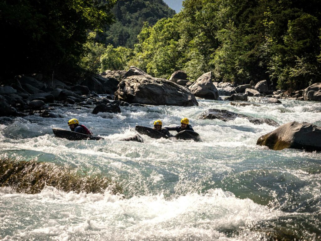 Aventure en hydrospeed sur l'Ubaye dans les alpes, encadrée de végétation dense et de rochers, activité parfaite pour les sensations fortes.